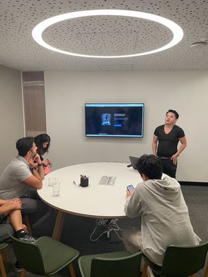 Justin leading a small-group trading workshop around a conference table